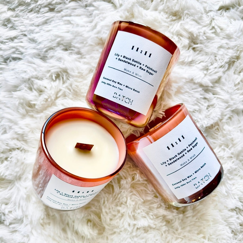 Three candles with visible labels on a textured white surface